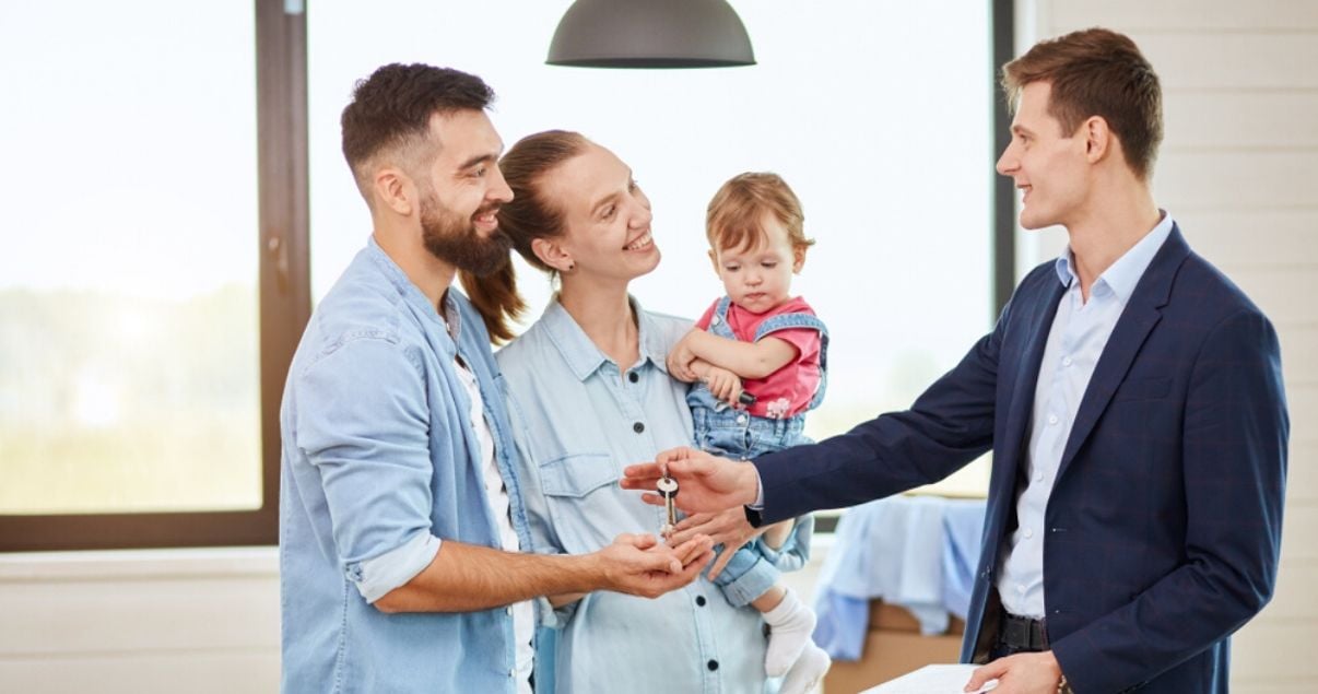 Familia recibiendo llave de su primer apartamento en el mercado inmobiliario 